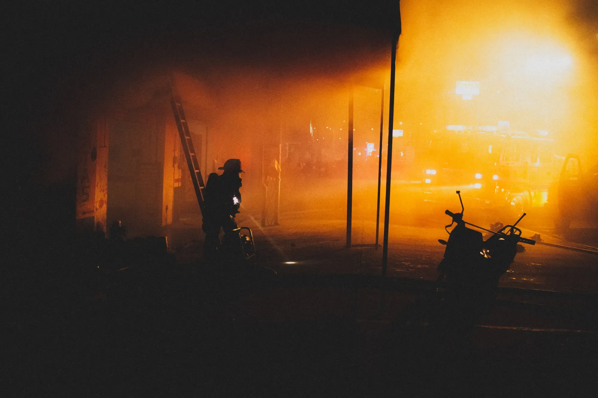 Feuerwehrmann mit Atemschutz im Brandrauch bei einem nächtlichen Einsatz